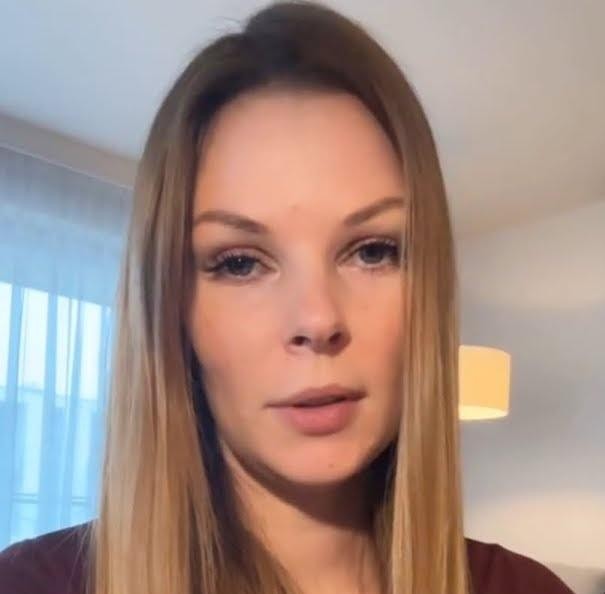 Małgorzata Tomaszewska korzystająca z Instagrama, uśmiechnięta, z telefonem w ręku, w swobodnej stylizacji, symbolizująca aktywność w mediach społecznościowych.
