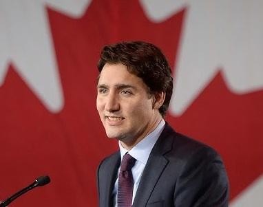 Justin Trudeau podczas spotkania z obywatelami Kanady, uśmiechnięty i przystępny, symbolizujący jego bliskość z ludźmi.