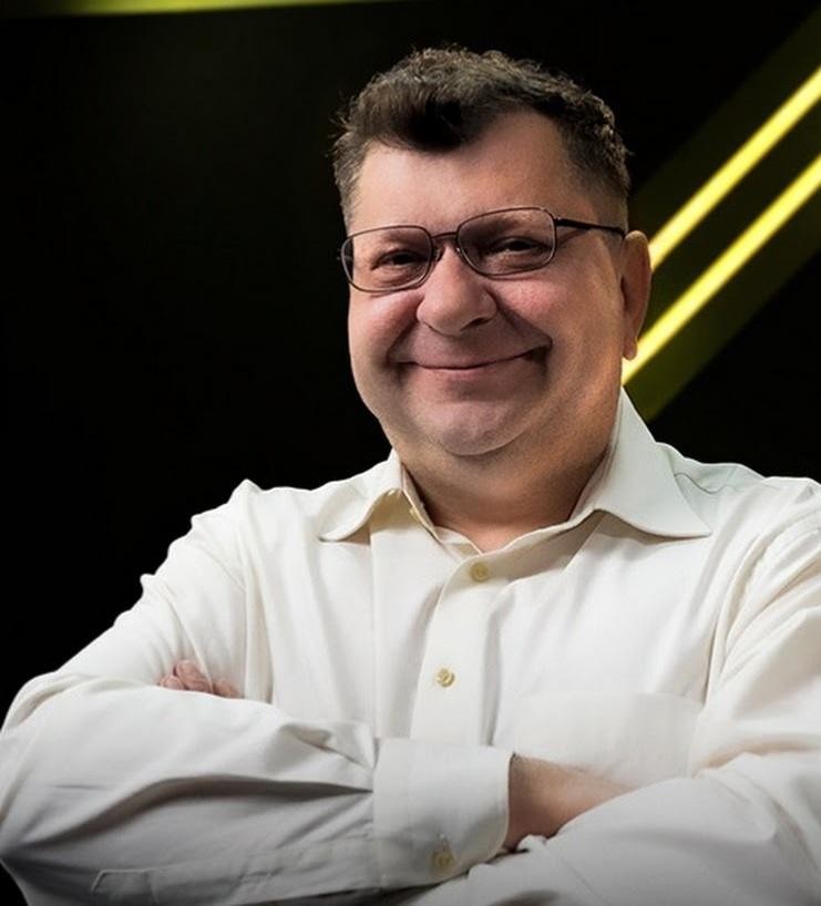 Zbigniew Stonoga trzymający smartfon z widocznym profilem Instagrama, symbolizujący jego aktywność w mediach społecznościowych i bezpośredni kontakt z odbiorcami.