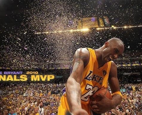 Kobe Bryant uśmiechnięty, w garniturze, trzymający statuetkę Oscara, w tle eleganckie otoczenie.