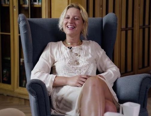 Aleksandra Domańska śmieje się spontanicznie, ukazując swoją naturalną charyzmę i energię, być może na planie filmowym.