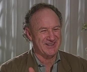Gene Hackman w jednej ze swoich ikonicznych ról filmowych, ukazujący intensywność i kunszt aktorski, z dramatycznym oświetleniem podkreślającym wyraziste rysy twarzy.