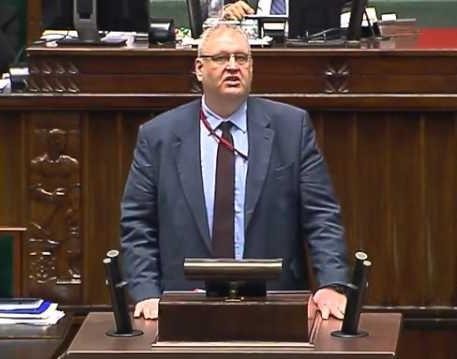 Bogdan Święczkowski w trakcie wystąpienia publicznego, symbolizującego jego rolę w polskim wymiarze sprawiedliwości.