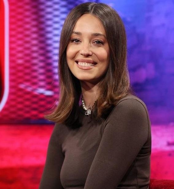 Izabella Krzan dynamicznie prowadząca program telewizyjny w jasnym, nowoczesnym studiu, pełna energii i profesjonalizmu.