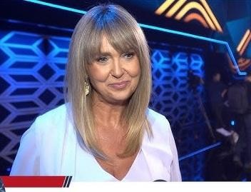 Ewa Wachowicz w kuchni, dynamicznie gotująca lub prezentująca danie, uśmiechnięta i pełna pasji.