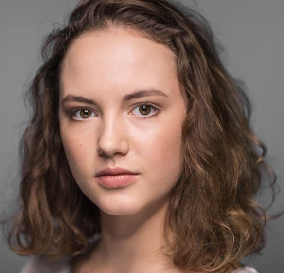 Martyna Byczkowska na planie filmowym, skupiona, z elementami scenografii w tle.