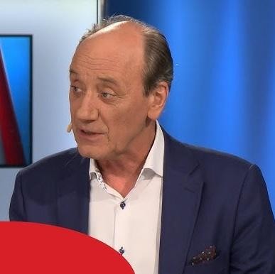 Dariusz Szpakowski w trakcie komentowania meczu, z mikrofonem, oddający swoją ekspresję i zaangażowanie.