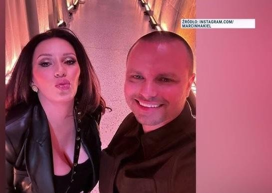Marcin Hakiel i Dominika Serowska uśmiechnięci, obejmujący się, w ciepłej i naturalnej scenerii.