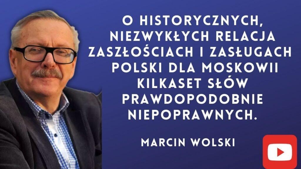 Ilustracja Marcina Wolskiego otoczonego elementami symbolizującymi jego karierę pisarską (książki, maszyna do pisania) i radiową (mikrofon, fale radiowe), z subtelnymi nawiązaniami do podróży i satyry.